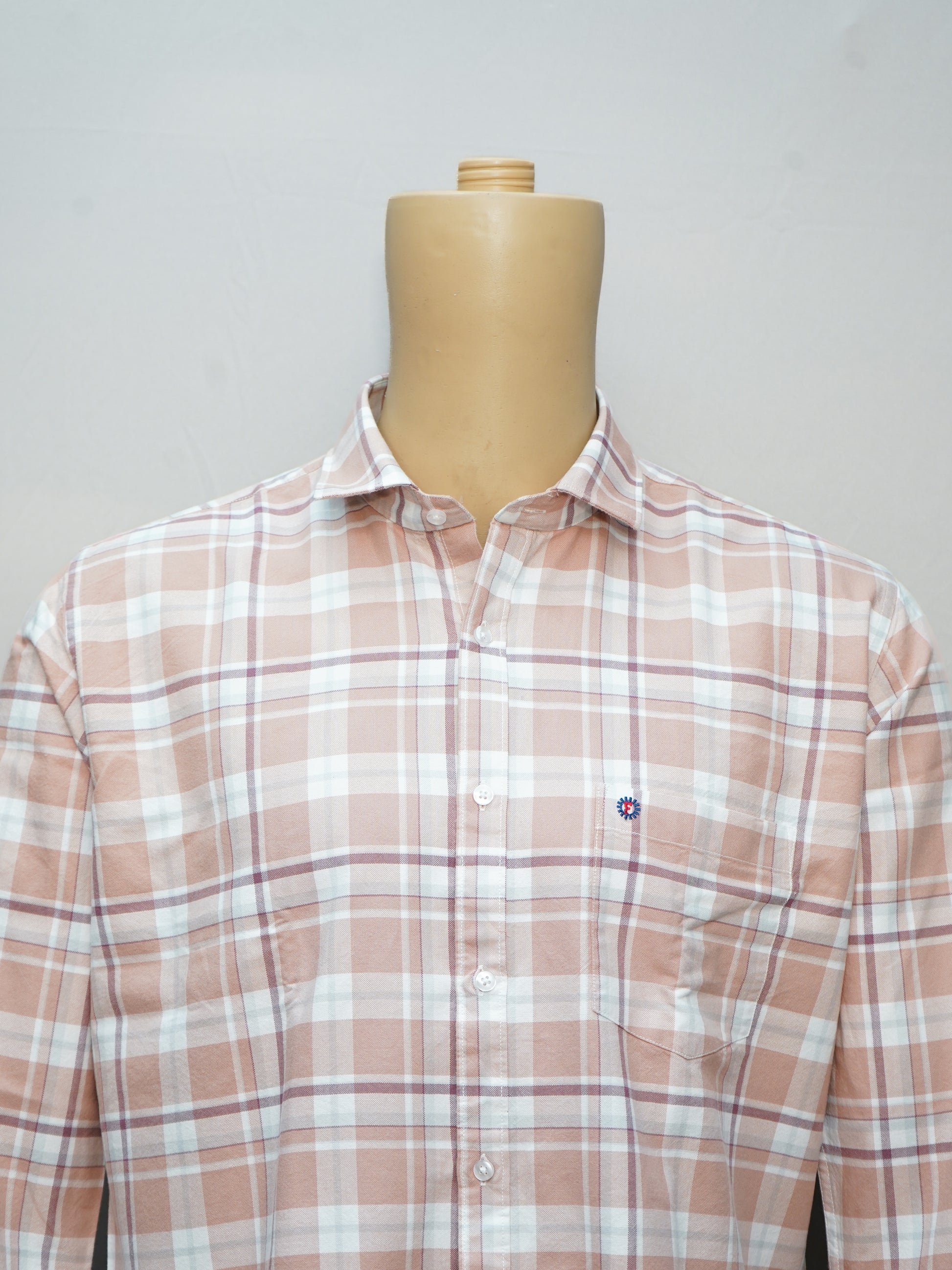 Close-up of a peach beige check men's shirt, highlighting the soft fabric and checkered pattern details.