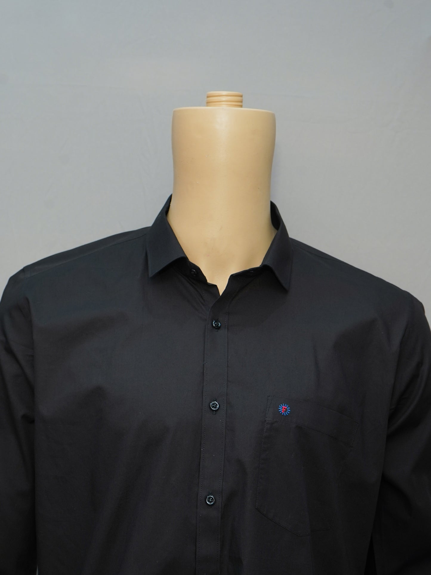 Close-up of a jet black formal men's shirt, highlighting its premium fabric and sharp collar details.