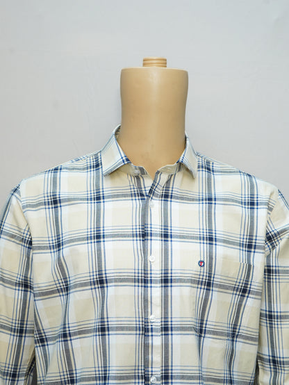 Close-up of a beige and blue check men's shirt, highlighting the fine checkered pattern and button-down collar.