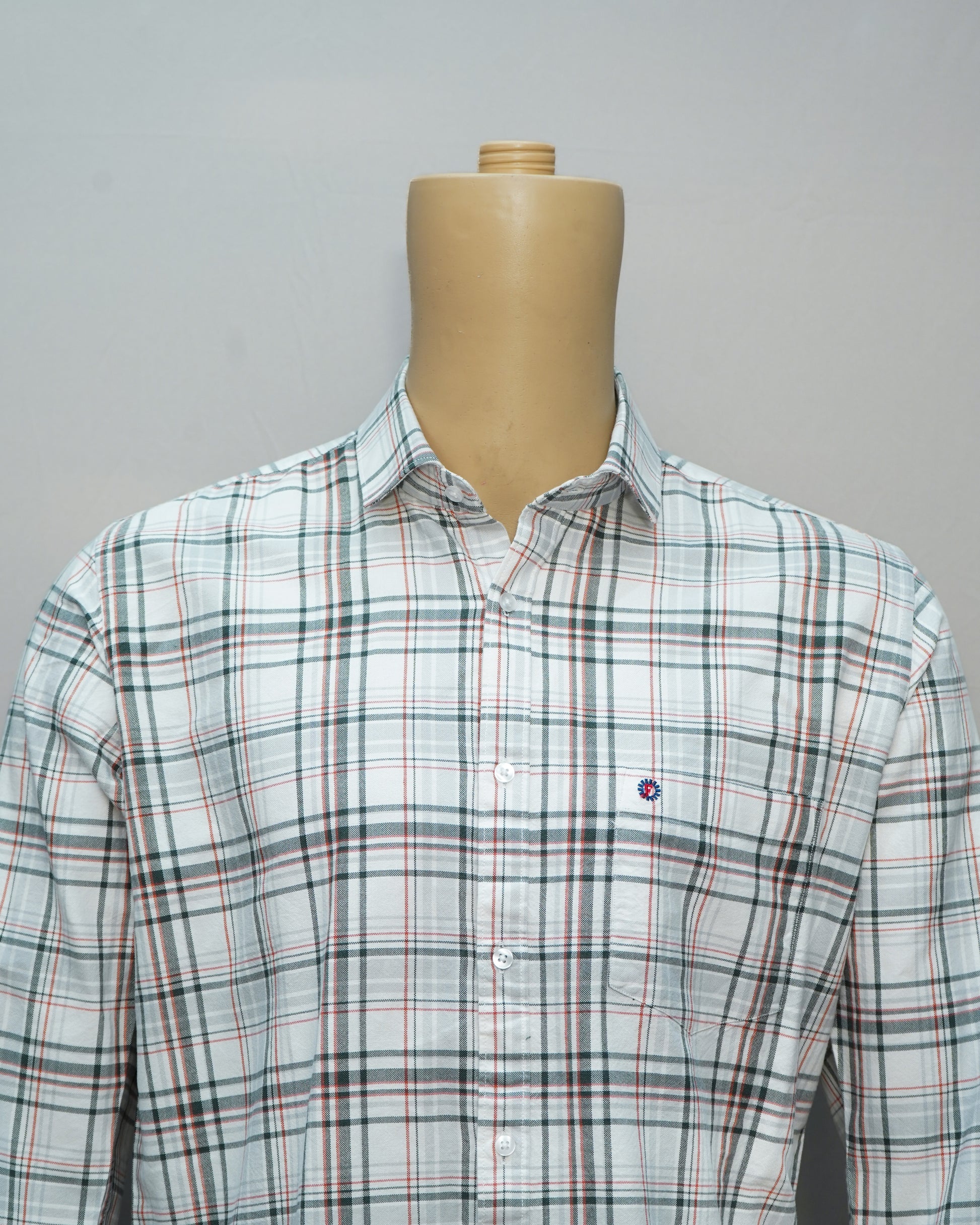 Close-up of white check shirt with green and red accents