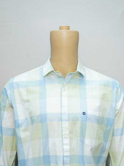 Close-up view of pastel green and blue check shirt with classic collar and chest pocket.