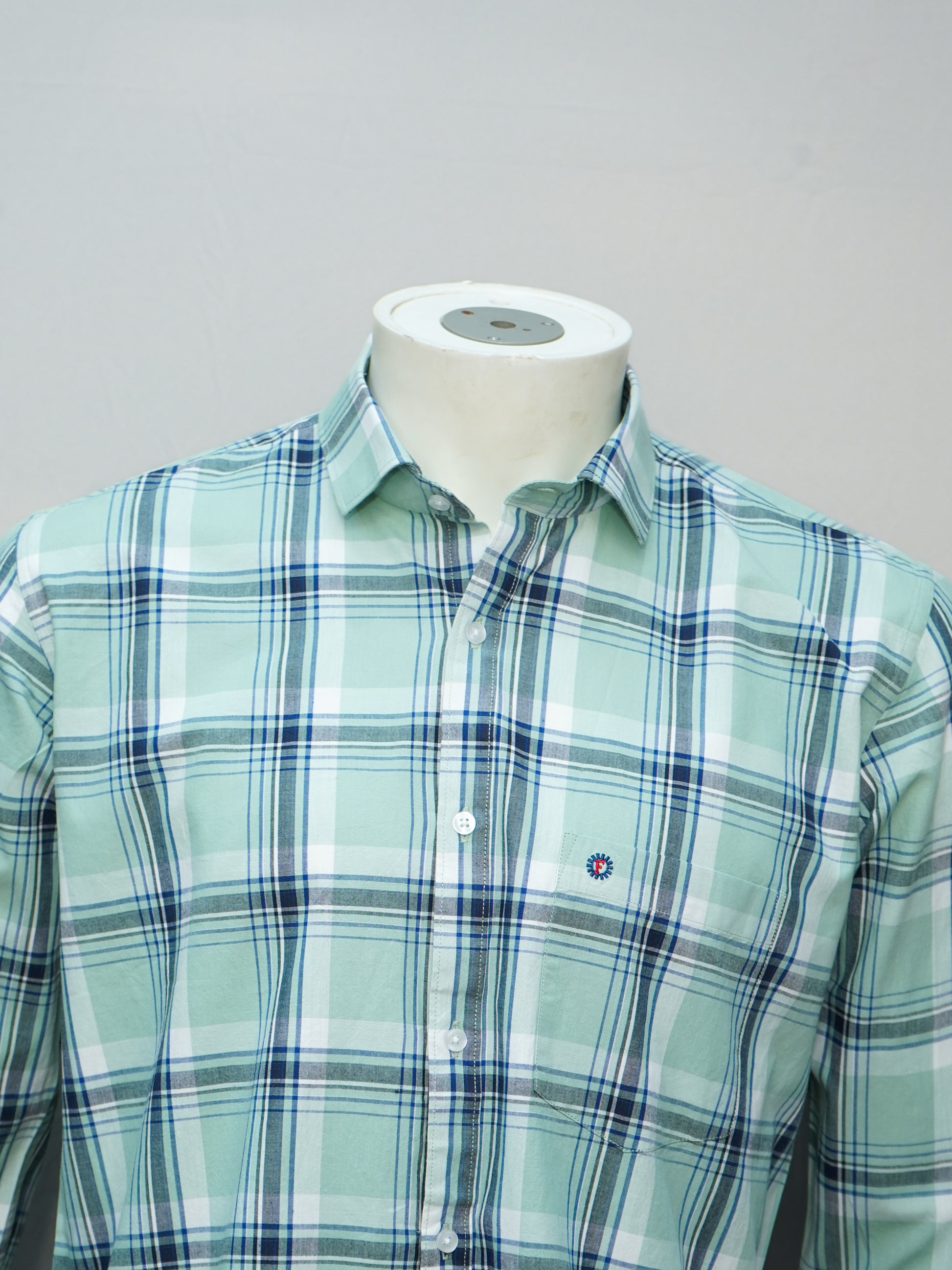 Close-up view of a mint green check men's shirt, highlighting the check pattern and collar details.